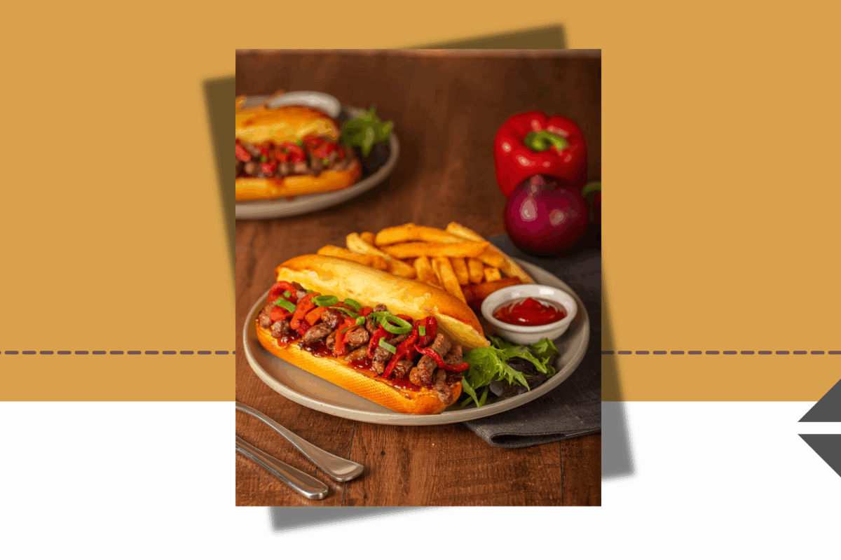 Philly Cheesesteak sandwich filled with shaved beef, melted cheese and sautéed onions, served with a side of golden chips at The Coffee Club, Ormiston Town Centre.