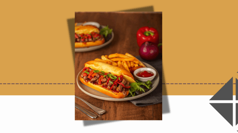Philly Cheesesteak sandwich filled with shaved beef, melted cheese and sautéed onions, served with a side of golden chips at The Coffee Club, Ormiston Town Centre.